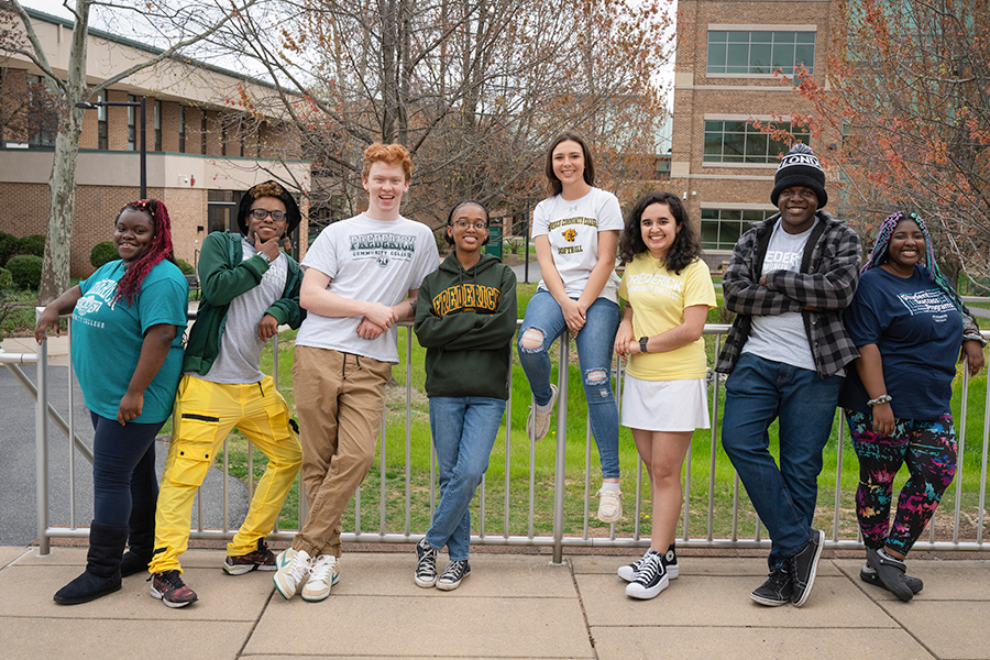 group of students leaning on a fence